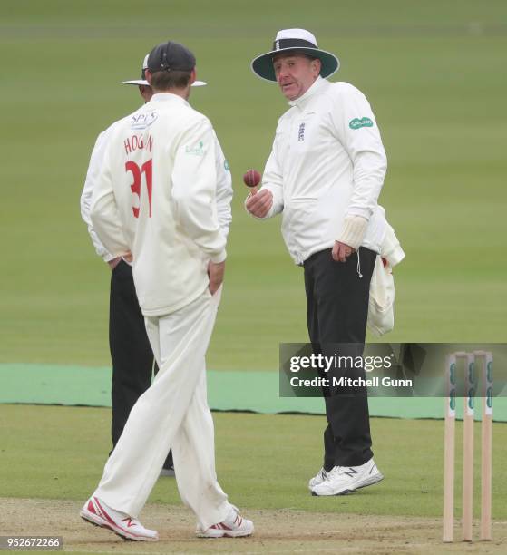 Umpire Robert Bailey tosses the ball to Michael Hogan of Glamorgan during day three of the Specsavers County Championship Division Two match between...