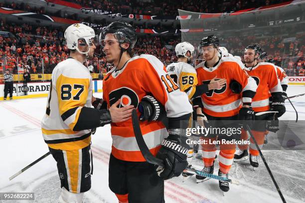 Travis Konecny and Michael Raffl of the Philadelphia Flyers shake hands with Sidney Crosby and Kris Letang of the Pittsburgh Penguins after the...