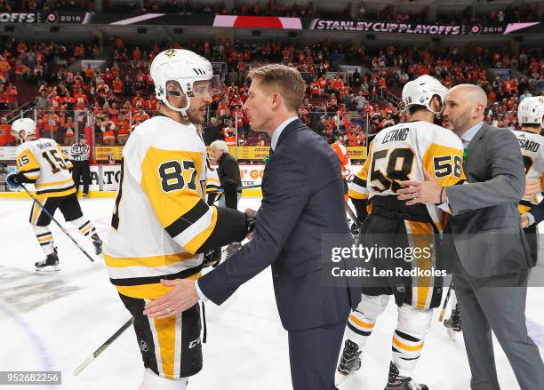Head Coach Dave Hakstol and Assistant Coach Ian Laperriere of the Philadelphia Flyers shake hands with Sidney Crosby and Kris Letang of the...