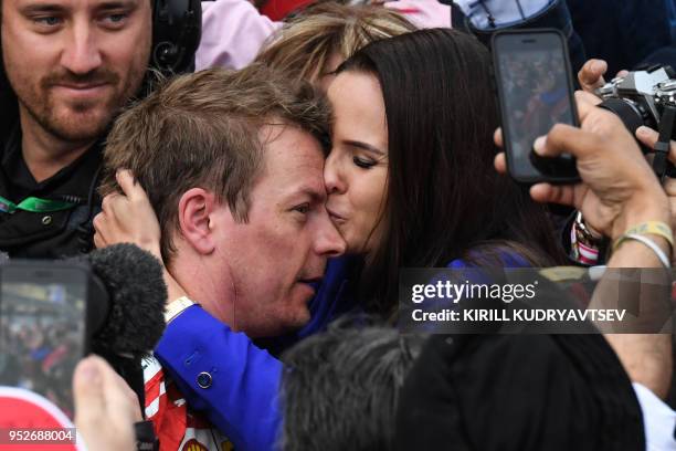 Second placed Ferrari's Finnish driver Kimi Raikkonen celebrates with his wife Minttu Virtanen after the Formula One Azerbaijan Grand Prix at the...