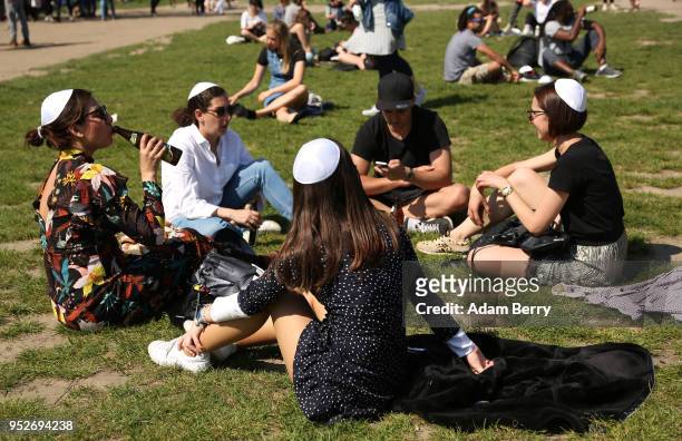 Visitors wear kippahs, or yarmulkes, handed out to them by volunteers in the Mauerpark public park during a day of demonstrations against...