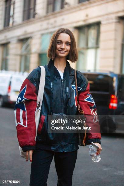 Brazilian model Luiza Scandelari wears a vintage-style leather USA jacket and carries an Olympus Pen camera and Louis Vuitton monogram bag on...