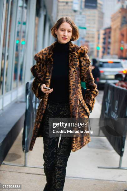 Model Luca Adamik wears a leopard fur coat, black shirt, and black embroidered pants on February 9, 2018 in New York City.
