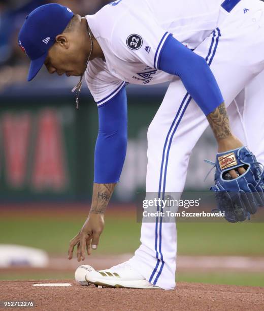 Marcus Stroman of the Toronto Blue Jays picks up the baseball on the mound as he gets ready to pitch the first inning during MLB game action against...