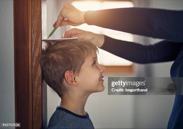 hoogte meten zoon's moeder - one children stockfoto's en -beelden