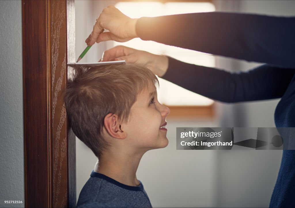 Mother measuring son's height