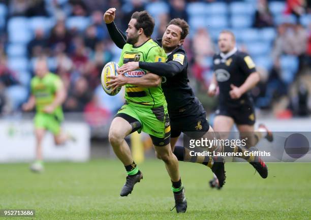 Cobus Reinach of Northampton Saints is tackled by Danny Cipriani of Wasps during the Aviva Premiership match between Wasps and Northampton Saints at...