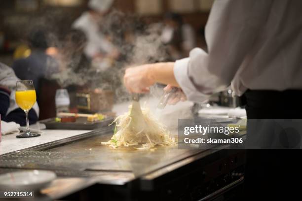 japanese chef cooking beef for client teppanyaki style - teppanyaki stock-fotos und bilder