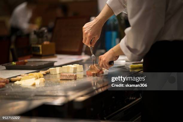 japanese chef cooking beef for client teppanyaki style - hibachi stock pictures, royalty-free photos & images