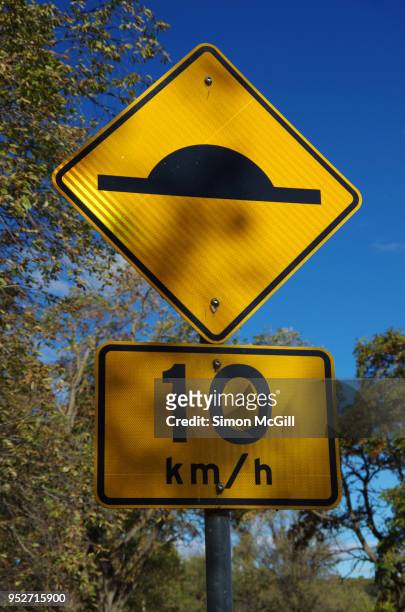 speed bump and 10 kilometres per hour speed limit signs - speed bump foto e immagini stock