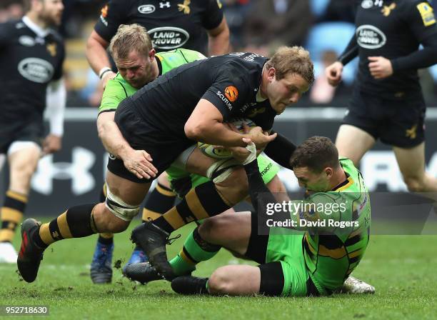 Joe Launchbury of Wasps is stopped by Mikey Haywood and George North during the Aviva Premiership match between Wasps and Northampton Saints at The...