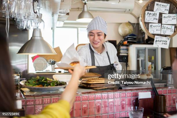 a woman manager who delivers food over the counter with gratitude - food sculpture stock pictures, royalty-free photos & images