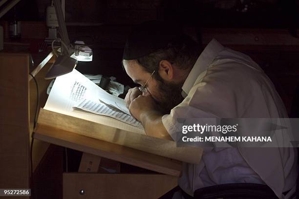 Rabbi Shai Abramovich writes a new Torah scroll in the ancient synagogue of the hilltop fortress of Masada in the Judean desert on December 21, 2009....