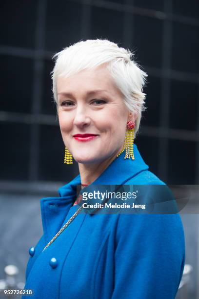 Guest wears yelllow earrings and a blue jacket on January 26, 2018 in Oslo, Norway.