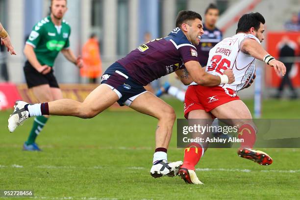 Justin Carney of Hull KR is tackled by Joel Moon of Leeds Rhinos during the BetFred Super League match between Hull KR and Leeds Rhinos at KCOM...