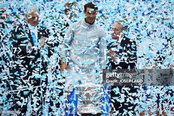 Confetti falls on Spain's Rafael Nadal as he celebrates with his trophy after winning the Barcelona Open ATP tournament final tennis match in...