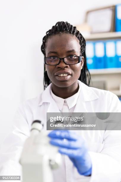 weibliche labor arbeiter mit mikroskop - adenovirus stock-fotos und bilder