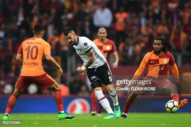 Besiktas' Spanish forward Alvaro Negredo vies for the ball with Galatasaray's Moroccan midfielder Younes Belhanda and Belgian defender Jason Denayer...