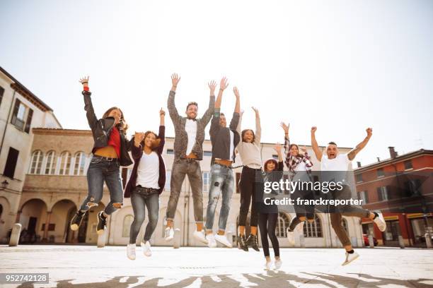 gruppe von freunden, die alle zusammen springen auf die stadt - school holiday stock-fotos und bilder