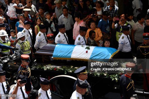 The frag-draped coffin of Guatemala City Mayor and former Guatemalan President Alvaro Arzu is escorted by military personnel during his funeral as...