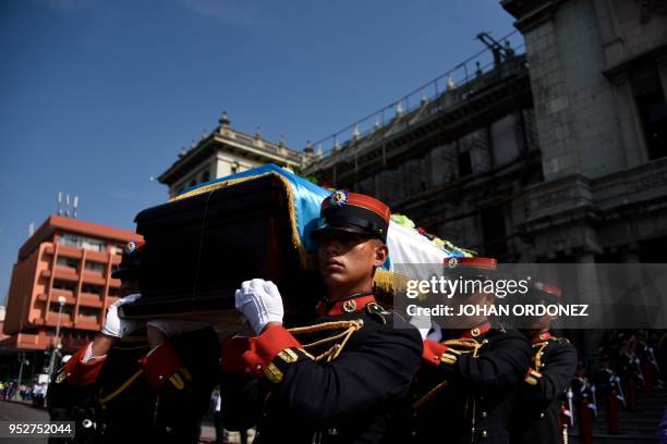 The frag-draped coffin of Guatemala City Mayor and former Guatemalan President Alvaro Arzu is escorted by military personnel during his funeral as...