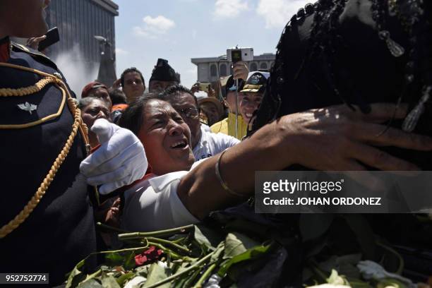 Woman grieves next to the frag-draped coffin of Guatemala City Mayor and former Guatemalan President Alvaro Arzu, during his funeral as they arrive...