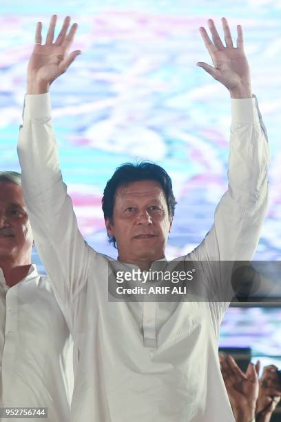 Pakistan opposition leader and leader of the Pakistani political party Pakistan Tehreek-e-Insaf Imran Khan waves at his supporters during a political...
