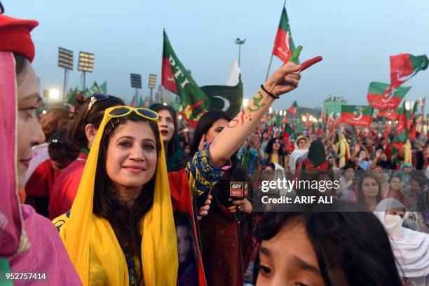 Supporters gesture and wave flags of the Pakistani political party Pakistan Tehreek-e-Insaf as they attend a rally with Pakistan opposition leader...