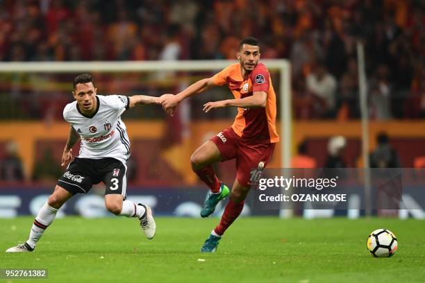 Galatasaray's Moroccan midfielder Younes Belhanda vies for the ball with Besiktas' Brazilian defender Adriano during the Turkish Spor Toto Super...