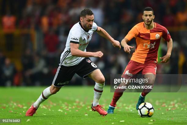 Besiktas' Serbian defender Dusko Tosic vies for the ball with Galatasaray's Moroccan midfielder Younes Belhanda during the Turkish Spor Toto Super...