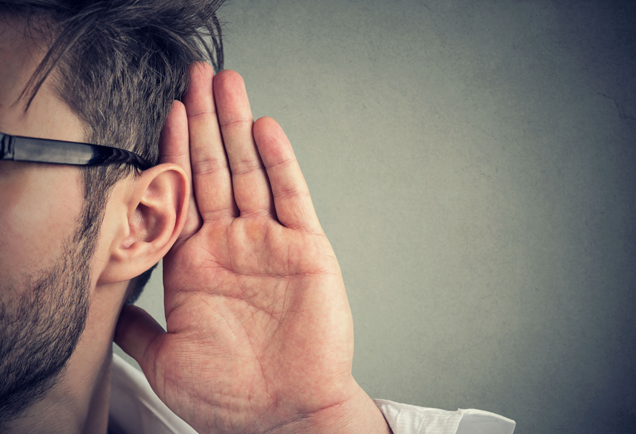 man holds his hand near ear and listens carefully man holds his hand near ear and listens carefully