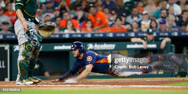 Jake Marisnick of the Houston Astros scores in the third inning on a sacrifice bunt by Jose Altuve against the Oakland Athletics at Minute Maid Park...