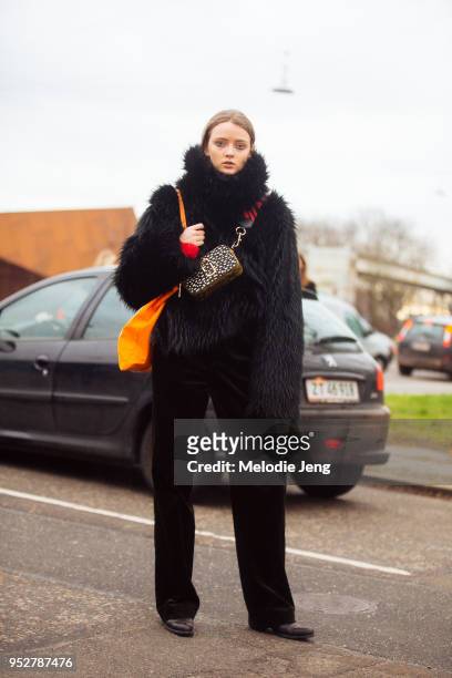 Model Clara McNair wears a black fur coat and pants and Marc Jacobs small camera bag at Copenhagen Fashion Week Autumn/Winter 18 on February 01, 2018...