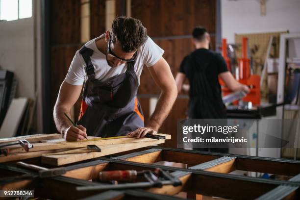 male carpenter measuring the board - carving stock pictures, royalty-free photos & images