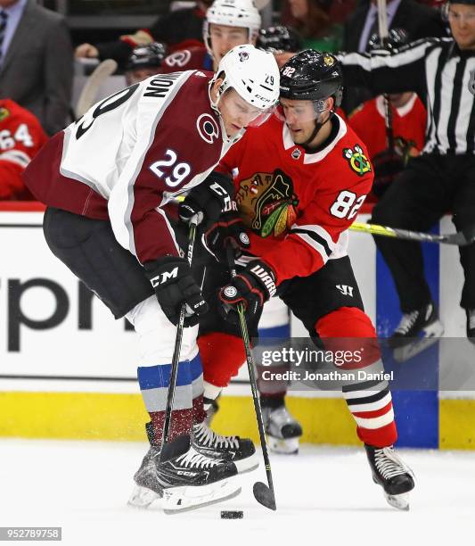 Nathan MacKinnon of the Colorado Avalanche and Jordan Oesterle of the Chicago Blackhawks battle for the puck at the United Center on March 6, 2018 in...