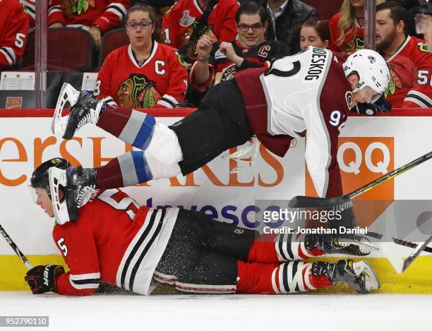 Gabriel Landeskog of the Colorado Avalanche and Connor Murphy of the Chicago Blackhawks get tangled up along the boards at the United Center on March...