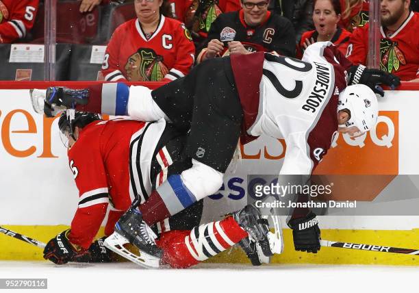 Gabriel Landeskog of the Colorado Avalanche and Connor Murphy of the Chicago Blackhawks get tangled up along the boards at the United Center on March...