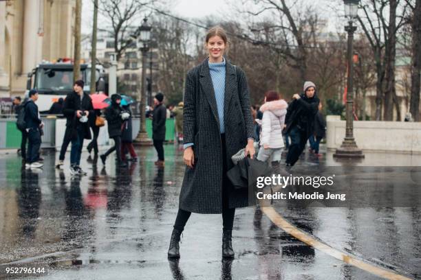 Model Bara Podzimkova wears a gray checkered coat, light blue sweater, and black boots and pants after the Chanel show on January 23, 2018 in Paris,...