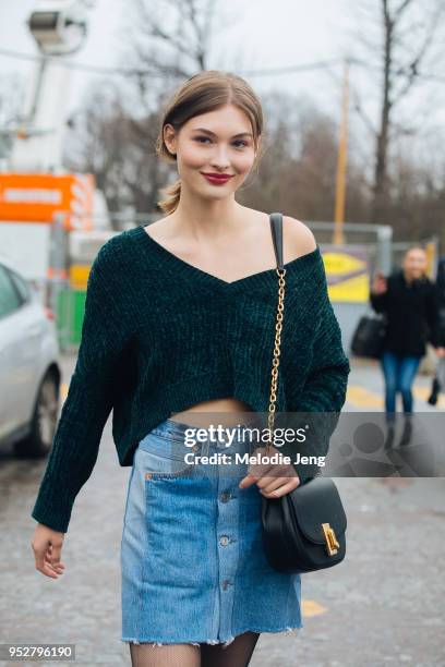 Model Grace Elizabeth wears a off-shoulder cropped green sweater, black purse, and denim button-up skirt after the Chanel show on January 23, 2018 in...