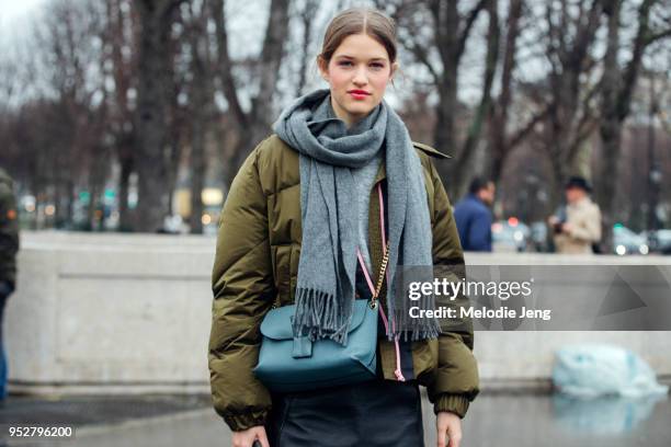 Model Femke Huijzer wears a gray scarf, green jacket, and light blue purse on January 23, 2018 in Paris, France.