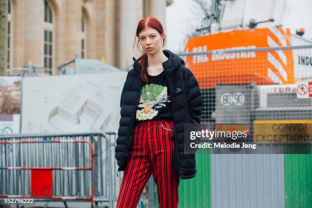Model Remington Williams wears a long L.L. Bean jacket, Green Day band t-shirt, and black and white striped pants after the Chanel show on January...