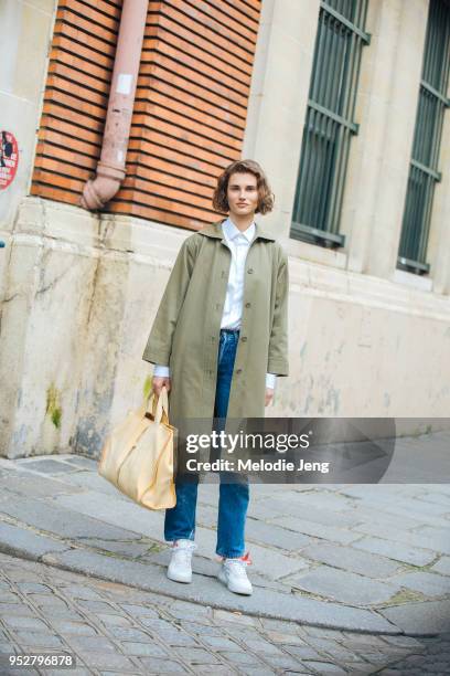 Model Giedre Dukauskaite wears a green coat, white tshirt, blue jeans, Nike Off-White Air Force 1 sneakers, and a yellow tote bag on January 24, 2018...