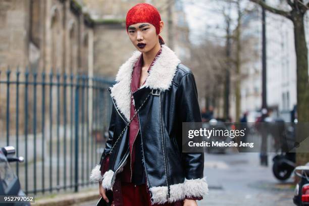 Chinese model Sijia Kang keeps the dramatic red hair cap, black eyebrows, and dark lipstick after the Margiela show on January 24, 2018 in Paris,...