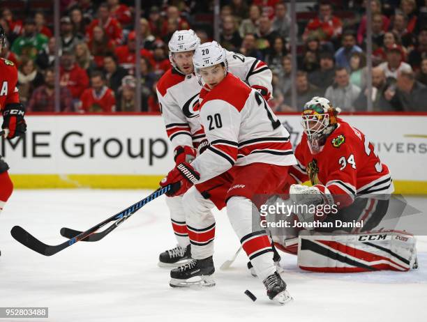 Sebastian Aho of the Carolina Hurricanes tries to control a pass in front of teammate Lee Stempniak and J-F Berube of the Chicago Blackhawks at the...