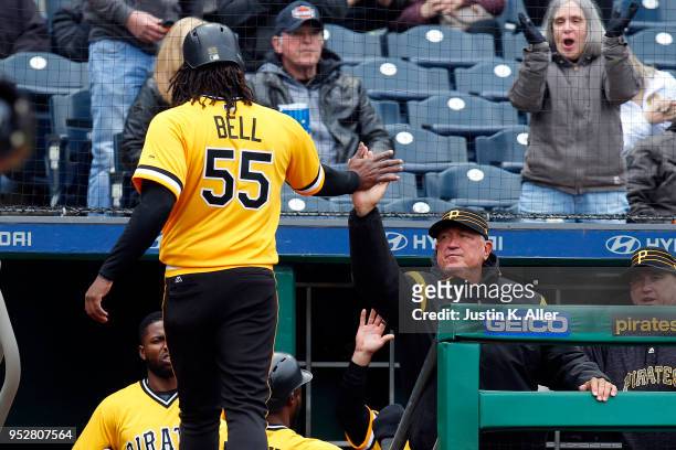Josh Bell of the Pittsburgh Pirates celebrates with manager Clint Hurdle after scoring on a two RBI single in the sixth inning against the St. Louis...