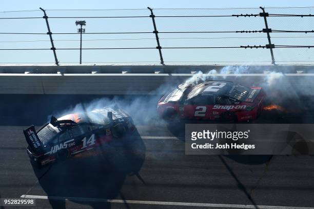 Clint Bowyer, driver of the Haas Automation Demo Day Ford, and Brad Keselowski, driver of the Snap On Ford, have an on track incident during the...