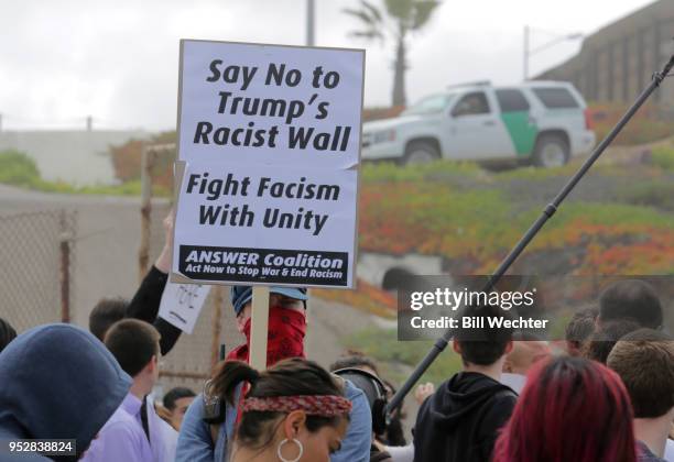 Pro-migrant caravan demonstrators rally at the west end of the U.S.-Mexico border as Border Patrol officers monitor the demonstration on April 29,...