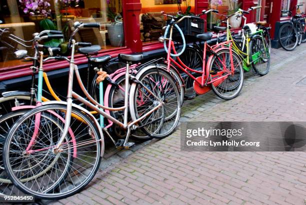 coloured bicycles parked outside shop - lyn holly coorg stock pictures, royalty-free photos & images