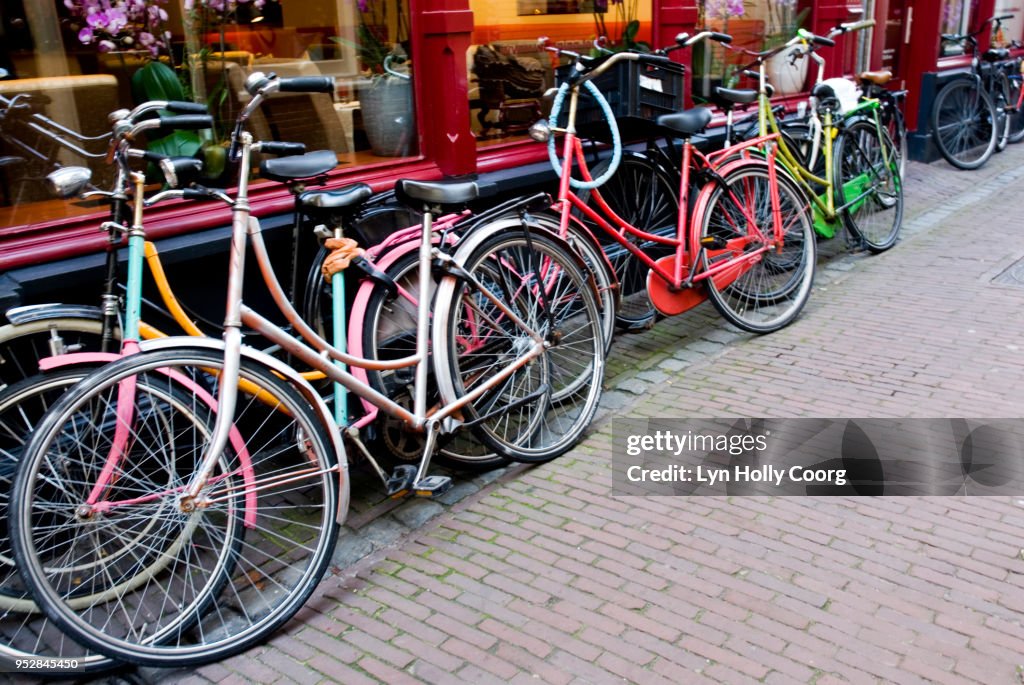 Coloured bicycles parked outside shop