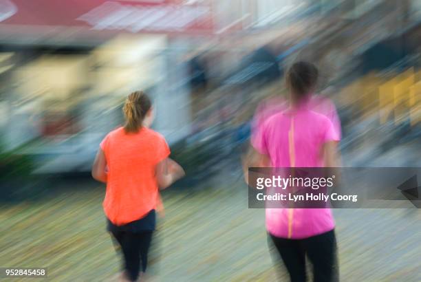 blurred image of two female joggers - lyn holly coorg stock pictures, royalty-free photos & images